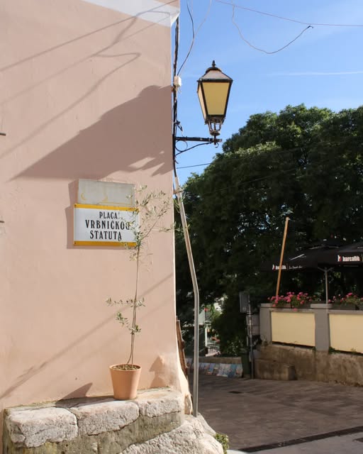 Ploča s natpisom Placa Vrbničkog statuta i ulična lampa