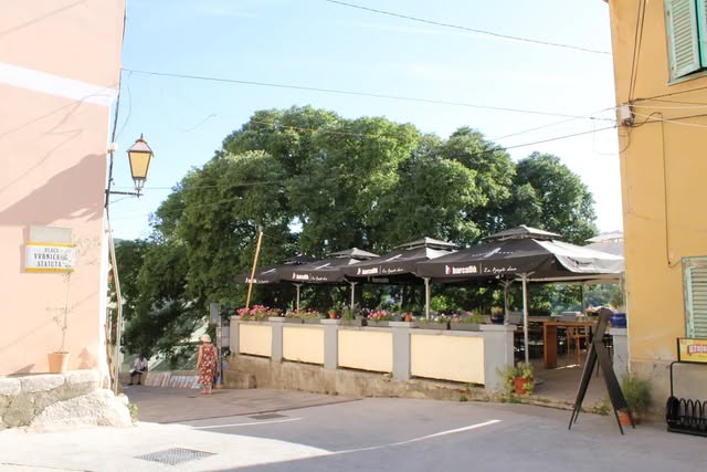 Trg u Vrbniku sa stolovima pod velikim drvetom